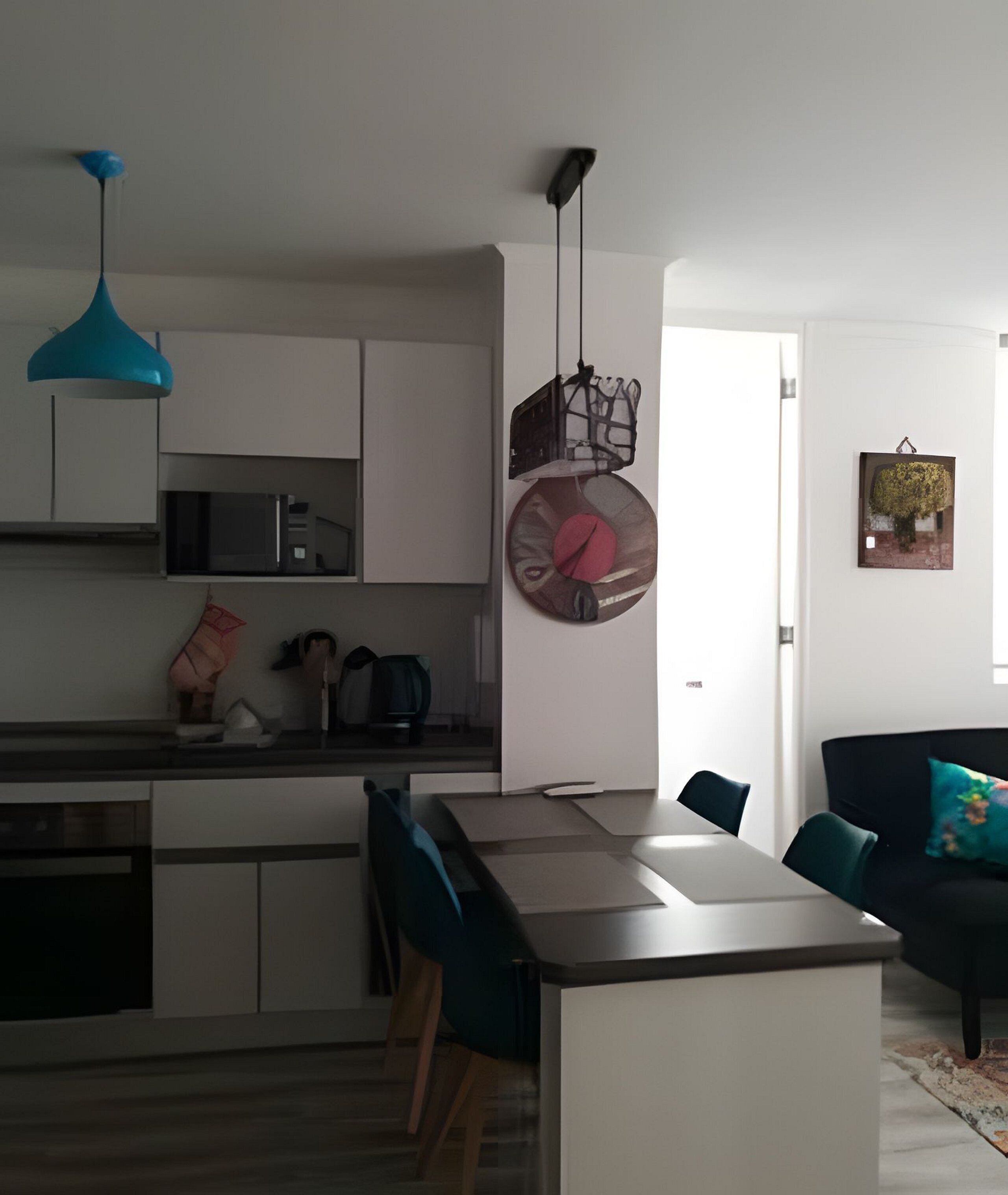 Een moderne keuken met witte kasten, een centraal eiland en een eethoek met tafel en stoelen.