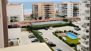 A residential area with multiple apartment buildings, a swimming pool, and parked cars. - Dept. 10th Floor, Cond. Pacific II (La Serena)