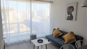Ein modernes Wohnzimmer mit einer Couch, einem kleinen Tisch und einem Sessel.