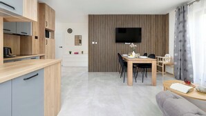 Eine moderne Küche mit Holzschränken und einem Essbereich mit Tisch und Stühlen.