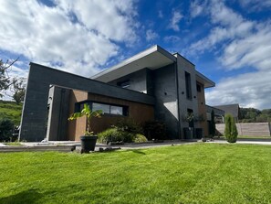 A modern two-story house with a flat roof, large windows, and a well-maintained lawn. - FAMILY HOME FOR 8 PEOPLE WITH A NORDIC HOT TUB—KIDS-FRIENDLY (Saint-Nabord)