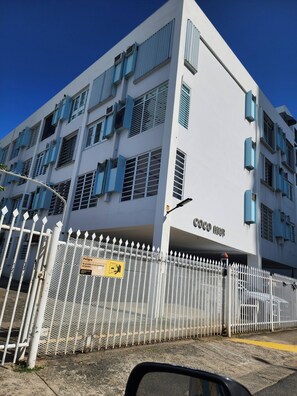 A multi-story building with a white facade, blue window frames, and a gated entrance. - LIS4B12 - SeaSide Beach II (Carolina)