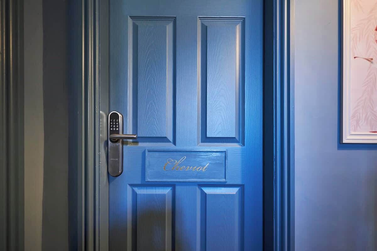 A blue door with a keypad lock and the word 'Chateau' engraved on it.