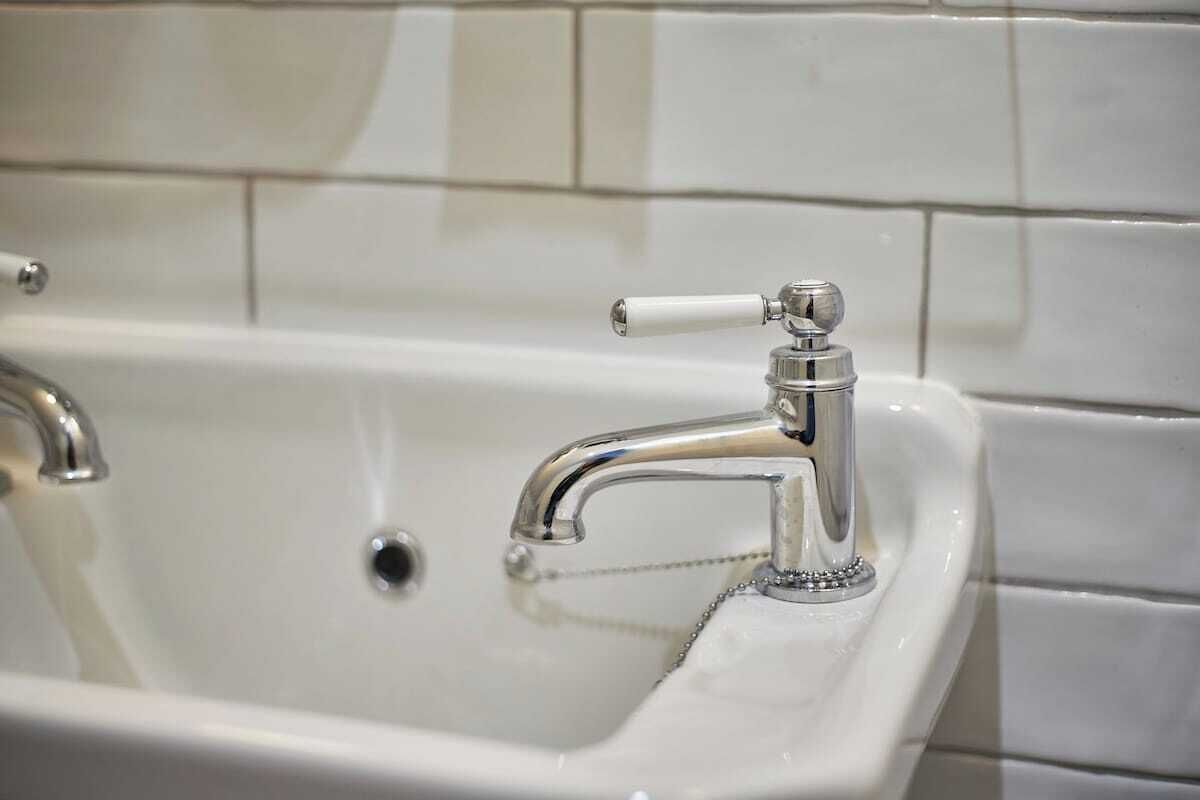 A bathroom sink with a chrome faucet and a drain.