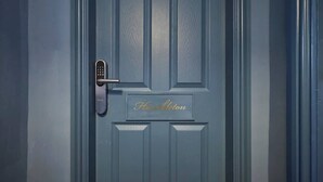 A blue door with a keypad lock and a nameplate reading 'Hamilton'.