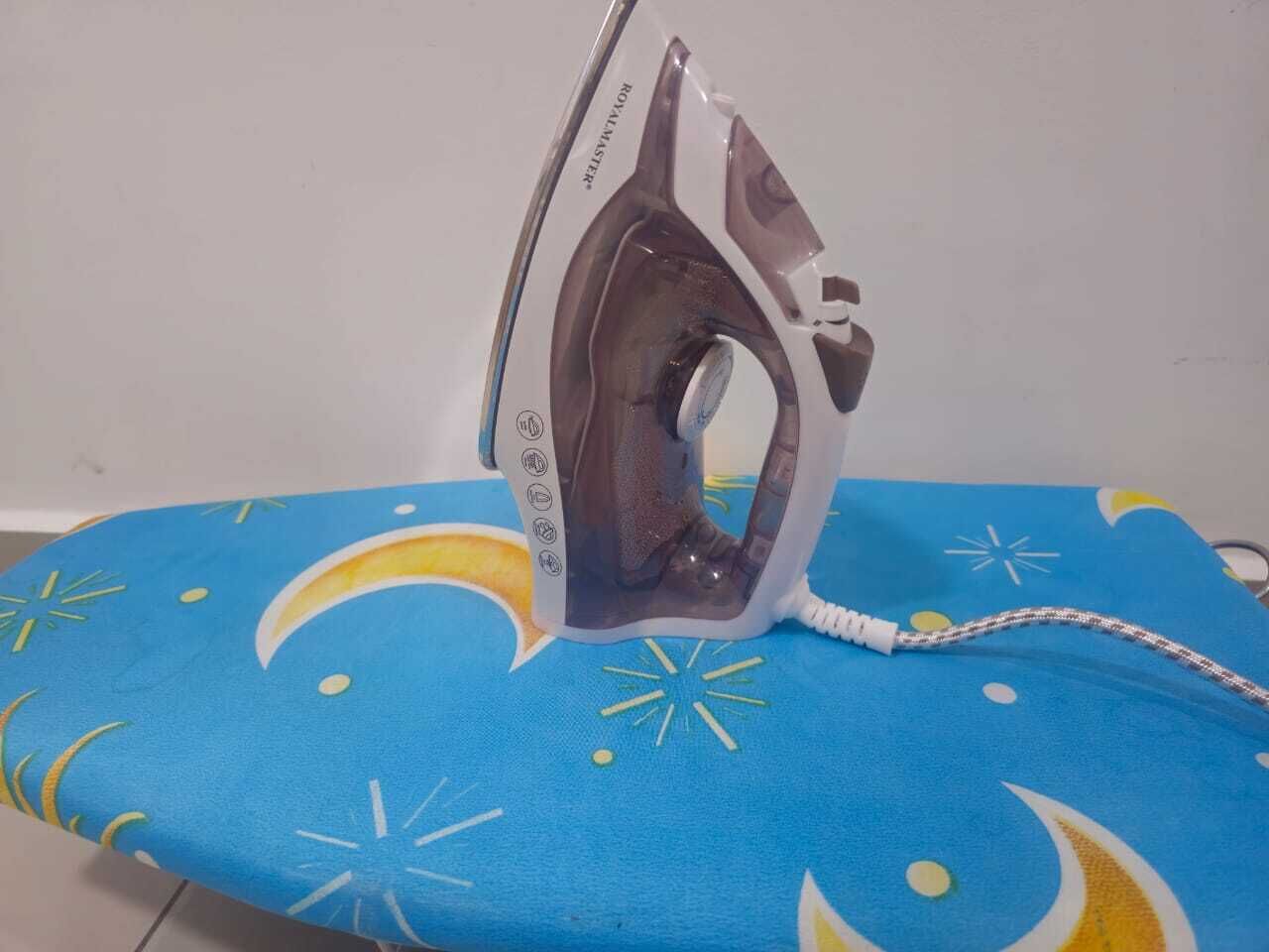 An iron on a blue cushion with star and crescent patterns.