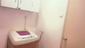 A small room with a white cabinet, a medical device on a table, and a door.