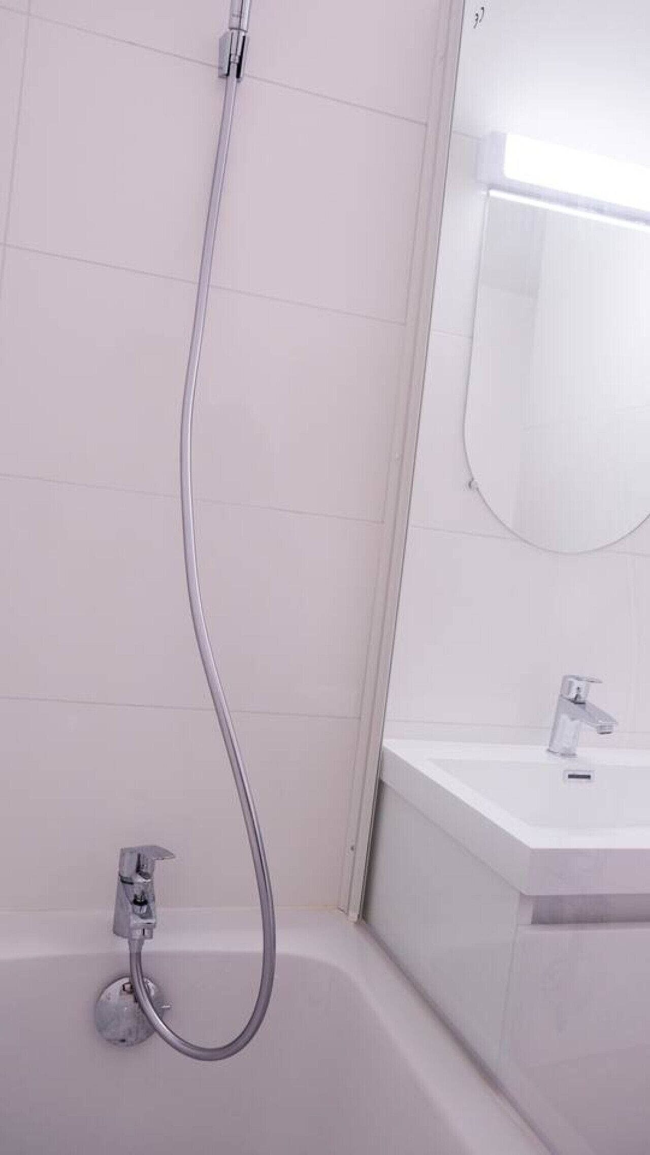 A bathroom with a shower, a sink, and a mirror.