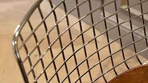 A metal chair with a grid pattern and a round table with a label. - Trendy studio apartment, 2 minutes from the very center of town (Caen)