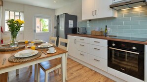 Eine moderne Küche mit weißen Schränken, einem Bosch-Backofen und einem Kühlschrank.