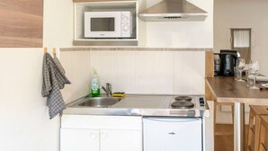 A compact kitchen with a microwave, sink, and stove. - Studio with free, private parking (Caen)