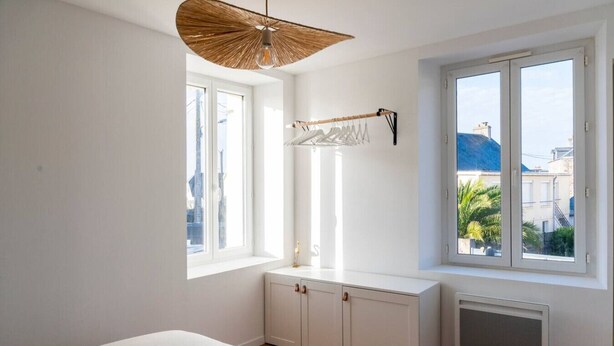 A bedroom with a bed, a radiator, a window with a view, and a hanging clothes rack. - Mansion near downtown and the beach (Granville)