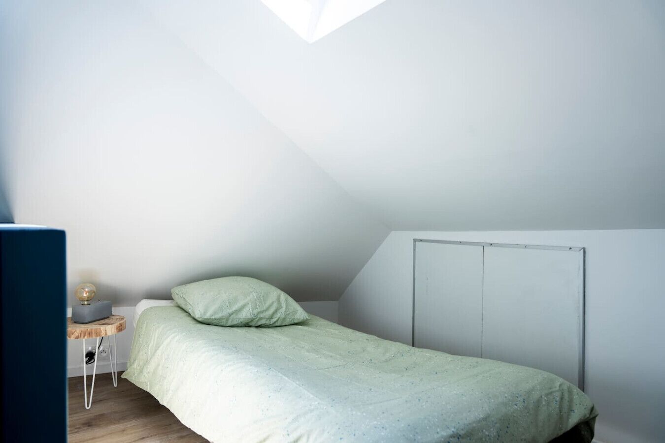 Une chambre à coucher avec un lit, une table de chevet, une lampe et une armoire.