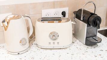 A kitchen with a white electric kettle, a white toaster, and a black coffee machine.