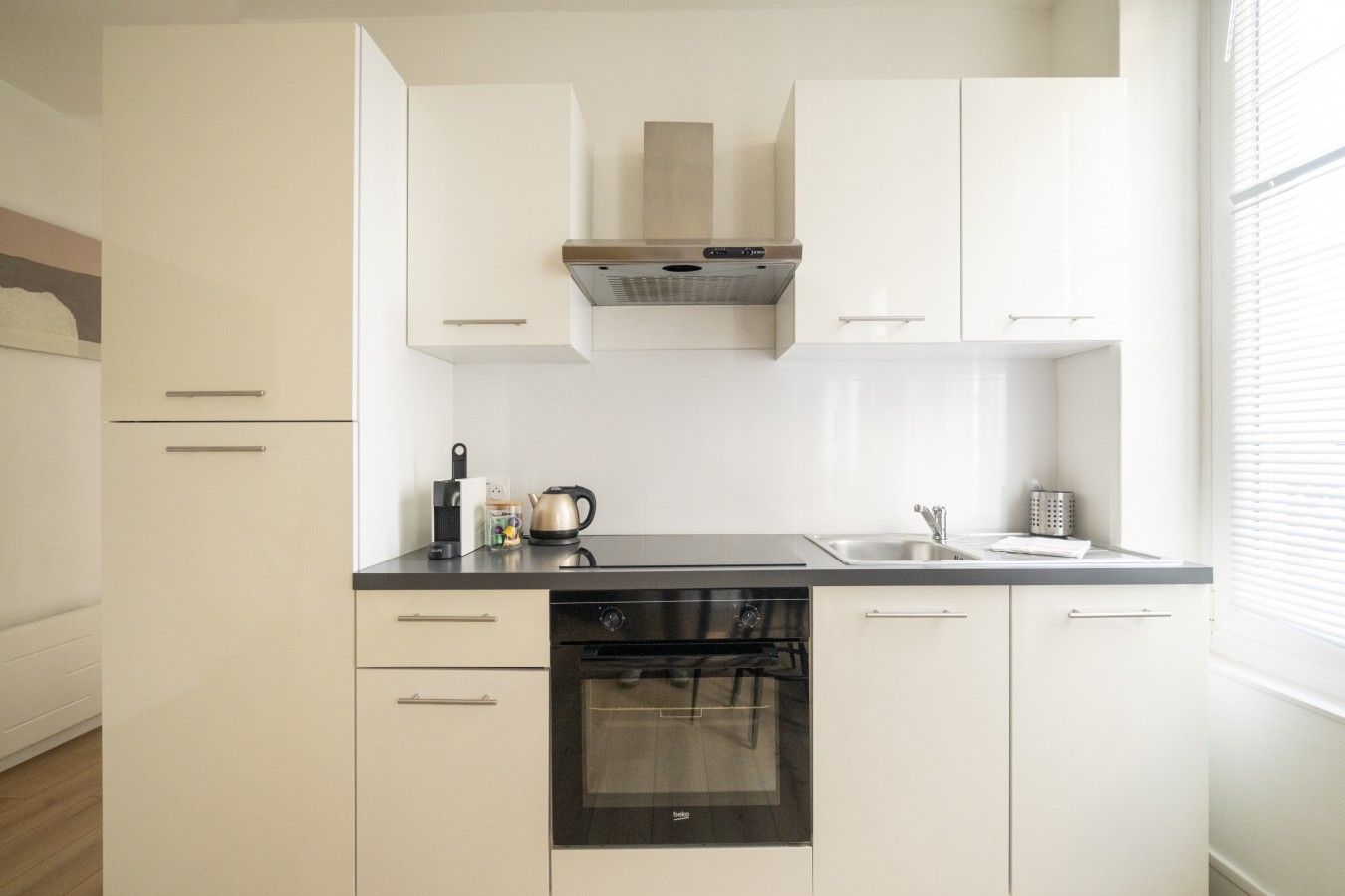 Una cocina compacta con lavavajillas, estufa y fregadero.