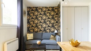 A living room with a sofa, a coffee table, a lamp, and a decorative bowl. - Nice studio apartment for two, near the university (Caen)