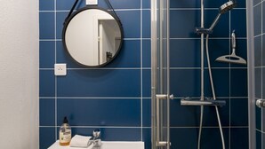 A bathroom with a sink, mirror, and shower. - Nice studio apartment for two, near the university (Caen)