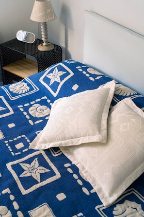 Tabla de planchar con plancha, cuna de viaje y ropa de cama 