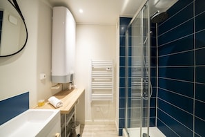 Un baño moderno con bañera, ducha y perchero para toallas.