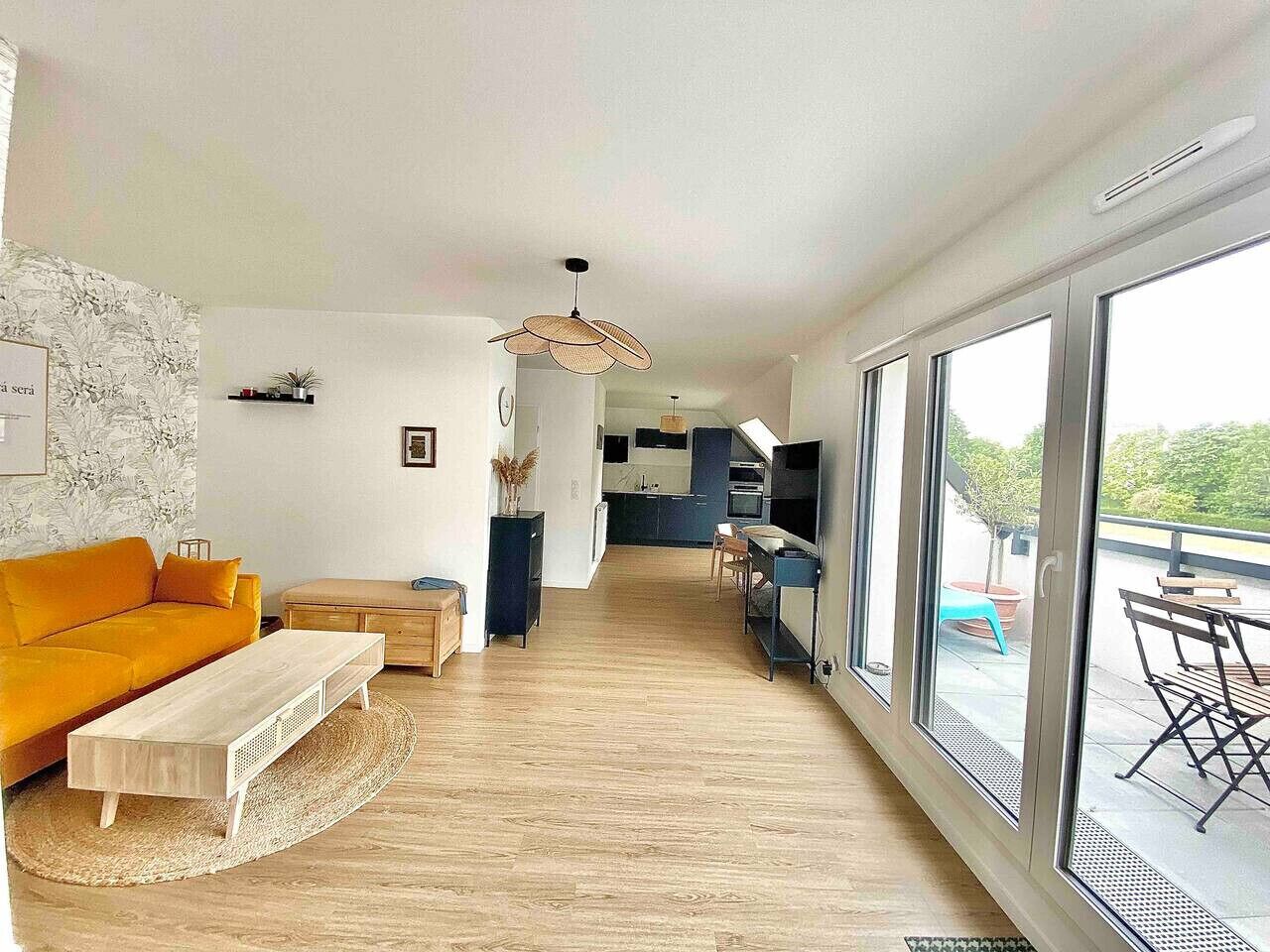 Un salon moderne comprenant un canapé, une table basse et un coin repas avec une table et des chaises.