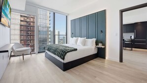 Una camera da letto moderna con un letto grande, una scrivania e vista sulla città.