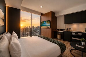 A modern hotel room with a large bed, a city view, a kitchenette, and a dining area. - Exectutive E11EVEN Studio Suite with Elite Amenities (Miami)