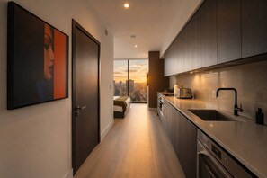 A modern kitchen with a large window, a view of the city, and a minimalist design. - Executive Luxury Suite with Resort Amenities (Miami)