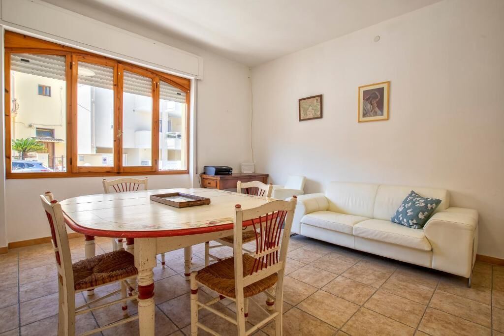 Un coin repas avec une table et des chaises, un canapé et deux tableaux encadrés au mur.