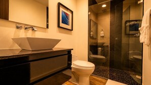 Une salle de bain moderne avec une douche à parois de verre, des toilettes blanches et un meuble-lavabo noir.