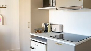 Una cuineta compacta amb microones, torradora i nevera petita.