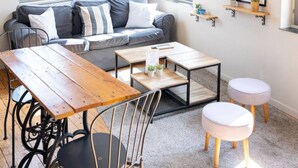 A cozy living room with a sofa, a wooden dining table, and a coffee table. - Apartment for 2, Place St. Sauveur (Caen)