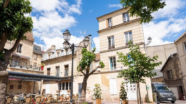 A street with buildings, outdoor seating, and a parked car. - Apartment for 2, Place St. Sauveur (Caen)