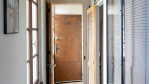A hallway with wooden flooring, a door at the end, and large windows on both sides. - Apartment for 2, Place St. Sauveur (Caen)