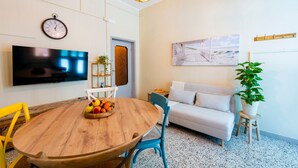 A room with a wooden dining table, chairs, a TV, a sofa, a plant, and a wall clock. - A charming 90-square-meter villa, perfect for six guests, featuring a private street-level entrance.The property is situated in a quiet area of ​​Silvi and enjoys a great location: thanks to a pedestrian path, you can reach the sea in just 10 minutes (Silvi)