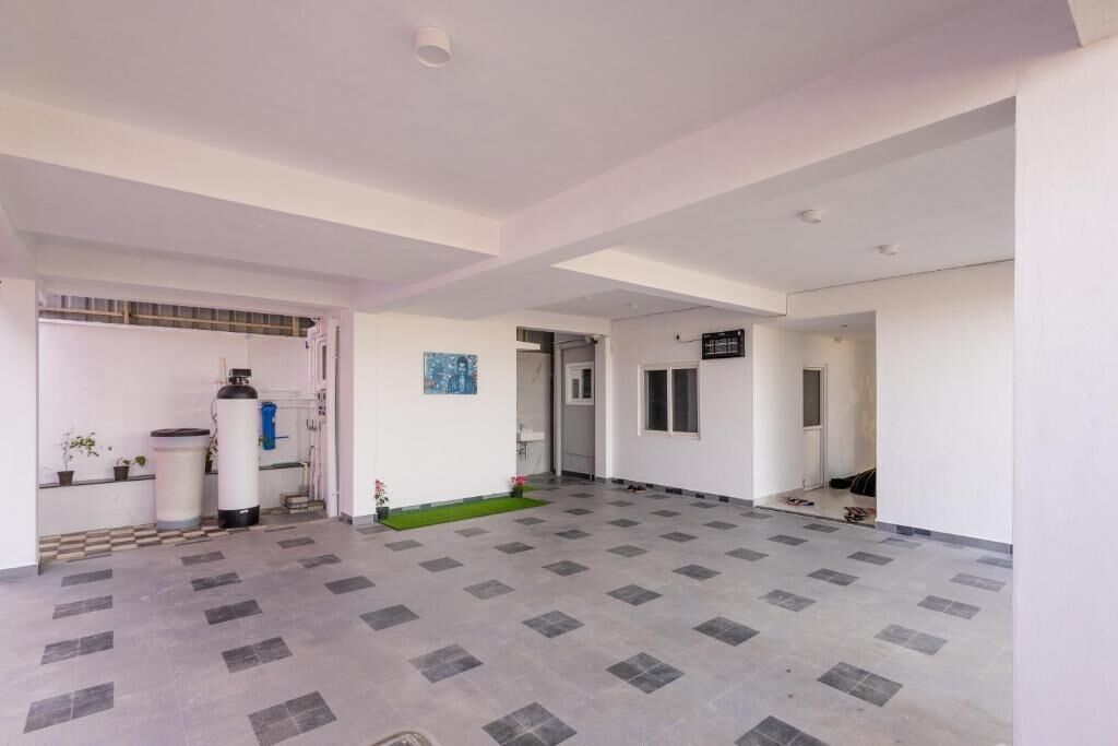 A spacious indoor area with a tiled floor, a water dispenser, and a small garden area.