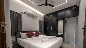 Un dormitorio moderno con cama, aire acondicionado, ventilador de techo y armario.