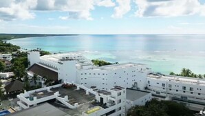 Ein Hotel an der Küste mit Dachpool, weißer Architektur und Blick auf den Ozean.