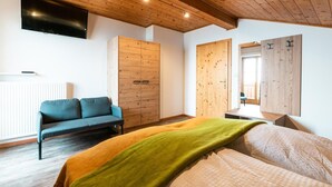 Une chambre à coucher comprenant un lit, un canapé, une armoire et un téléviseur.