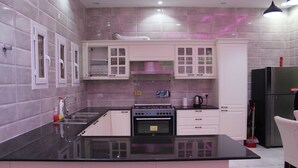 A modern kitchen with a black countertop, white cabinets, and a built-in oven.
