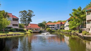 A serene water feature in a courtyard surrounded by multi-story buildings with red roofs. - Near Beach Coastal Getaway (Hilton Head Island)