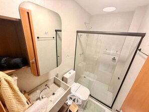 A modern bathroom with a glass-enclosed shower, a sink with a mirror, and a toilet. - Gamboa Oasis Patacho 180m Praia Patacho (Porto de Pedras)