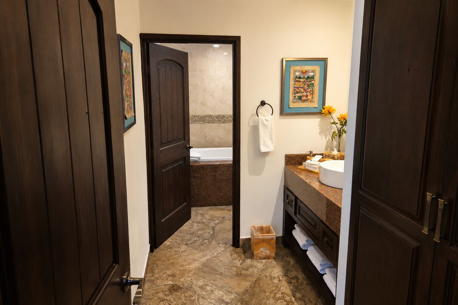 A bathroom with a bathtub, a sink with a vase of flowers, and a towel rack.