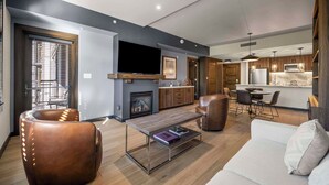 Ein modernes Wohnzimmer mit einer Couch, Ledersessel und Couchtisch.