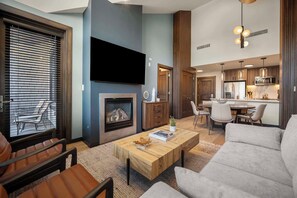 A modern living room with a fireplace, a television, and a dining area. - Capitol Peak Lodge 3518 (Snowmass Village)