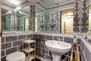 A bathroom with a large mirror, a sink, and a toilet. - Fossi Apartment by Mamo Florence (Firenze)