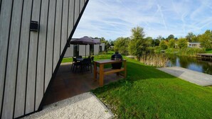 A modern building with a sloped roof, outdoor seating, a grill, and a pond. - Holiday Home in Kampen With Terrace (Kampen)