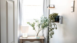 En gang med en træbænk, en lampe og en plante.
