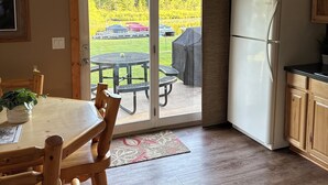 Una cocina con puerta corrediza de vidrio que da a un patio exterior con mesa y sillas.