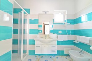 Ein Badezimmer mit Dusche, Waschbecken und Toilette.