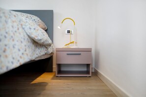 A bedroom with a bed, bedside table, lamp, and a power outlet. - Apartment 'Casa Ada' with Lake View, Balcony and Wi-Fi (Colico)